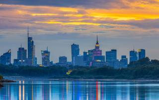 Skyline moderno di Varsavia con i grattacieli che si riflettono sul fiume Vistola al tramonto