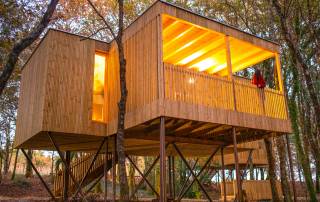 Un lodge di legno sopraelevato nel bosco dell'Enoturismo María Manuela in Galizia, ideale per una vacanza slow travel e glamping nella natura.